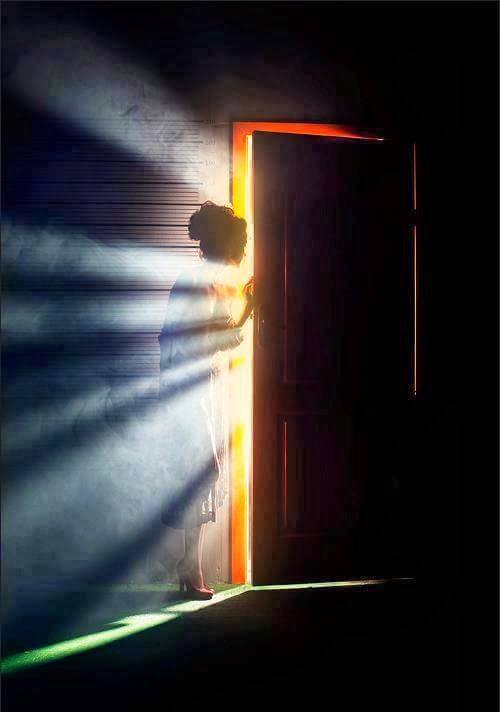 Une prte sombre entrouverte laissant passer un rayon de lumière vive